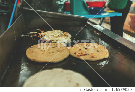Traditional grilled cheese pupusas. Closeup of traditional pupusas on grill Traditional grilled cheese pupusas. Closeup of traditional pupusas on grill 126579039
