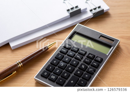Documents and calculator clipped together 126579336