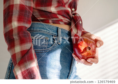 Woman Holding Ripe Pomegranate. Sunlight Falling on Hand and Fruit. Woman Holding Ripe Pomegranate. Sunlight Falling on Hand and Fruit. 126579469
