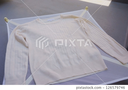 A sweater dried in the shade on a flat drying net 126579746