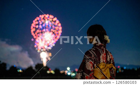 Image of a woman watching fireworks at a summer festival Background material Flyer, banner, video material AI-generated material 126580103