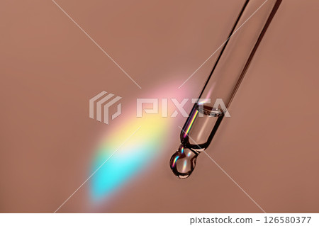 Pipette with cosmetic product with iridescent highlights in mocha mousse color 126580377