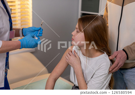 A Young Girl Receiving Vaccination in a Medical Setting That Ensures Her Wellbeing and Safety A Young Girl Receiving Vaccination in a Medical Setting That Ensures Her Wellbeing and Safety 126580594
