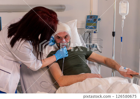 A patient is currently receiving medical care inside their hospital room for treatment needs A patient is currently receiving medical care inside their hospital room for treatment needs 126580675