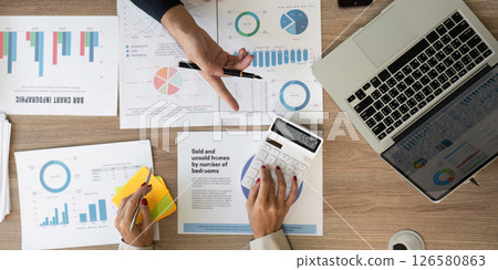 Overview of business reports and financial data on a modern workspace table. 126580863