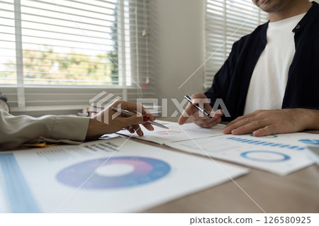 Detailed financial discussions with visual data representation. Detailed financial discussions with visual data representation. 126580925