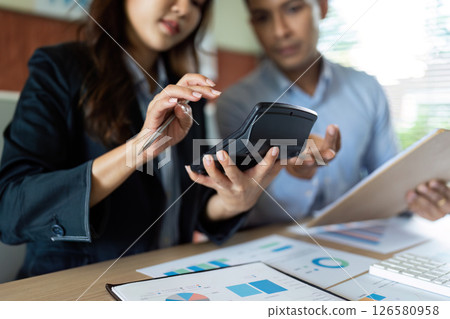 Financial Consultation. Colleagues analyzing data on calculators and digital devices. Financial Consultation. Colleagues analyzing data on calculators and digital devices. 126580958