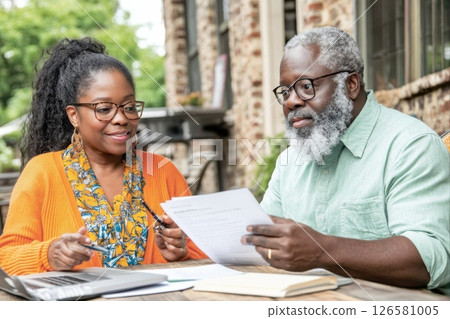 Two professionals discuss financial plans outdoor park collaborative meeting relaxed environment engaging dialogue effective strategy 126581005