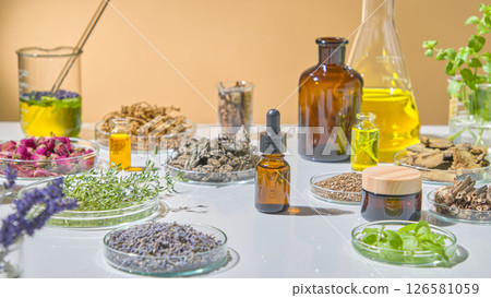 Natural essential oil display with amber bottles, green extracts, dried flowers, and lab tools for herbal research. Advertising photo for product with ingredient from herbal 126581059