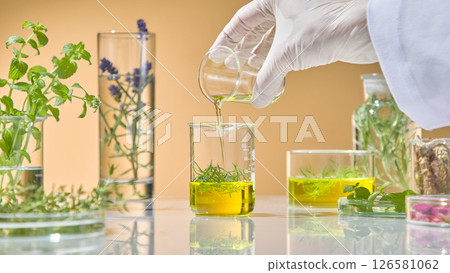 Researcher pouring second layer of herbal extract into beaker for layered infusion test using natural ingredients. Many glass laboratory jars of medicinal herbs are displayed around Researcher pouring second layer of herbal extract into beaker for layered infusion test using natural ingredients. Many glass laboratory jars of medicinal herbs are displayed around 126581062