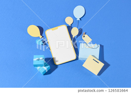 A smart phone lies in the center with gift boxes and paper icons scattered around on a dual blue background, portraying e-shopping and discounts. Flat lay, empty space for 126581664