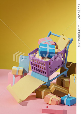 A cart overflowing with boxes and paper props rolls down a pink hill, creatively symbolizing delivery rush and retail excitement. Vertical frame, blank space for design 126581665