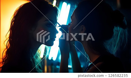 Makeup Artist Applying Mascara with Dramatic Lighting and Neon G 126582235