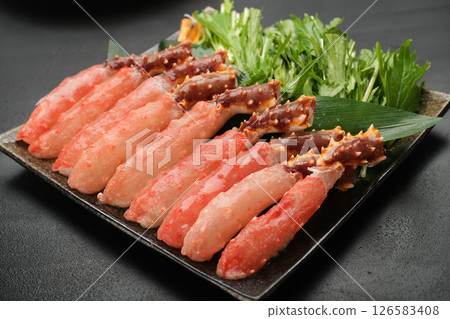 King crab shabu-shabu (raw portions) is served on a black plate. The background is black. King crab shabu-shabu (raw portions) is served on a black plate. The background is black. 126583408