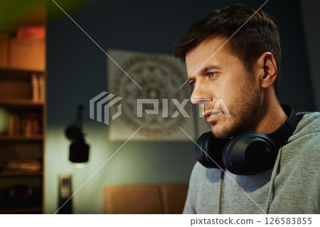 Man sitting at desk and looking at computer monitor. Freelancer focused on screen while working remotely. Concept of concentration, productivity and digital freelance work 126583855
