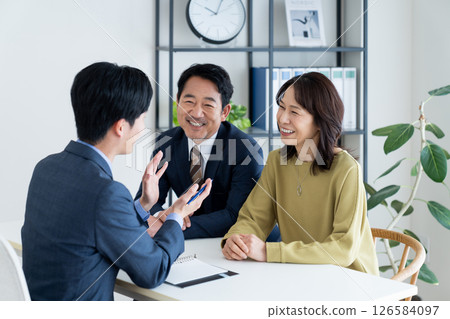 Middle-aged couple consulting with a consultant Middle-aged couple consulting with a consultant 126584097