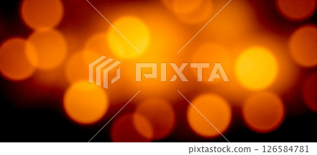 Close abstract glowing orange lights with soft blur and bokeh pattern on dark background golden festive visual impression 126584781