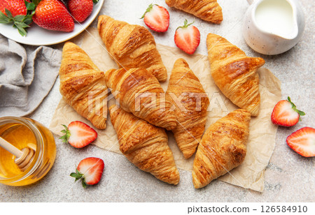 Freshly baked croissants with strawberries and honey for breakfast 126584910