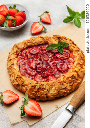 Delicious homemade strawberry galette with almond petals and fresh mint 126584920