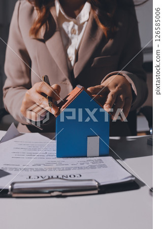 Female Real Estate Broker presenting and advised to model home and building project detail in the office, sign purchase sales contract, agreements concerned mortgage loan offer and insurance. 126585006