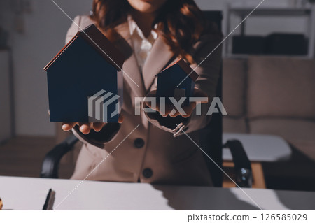Female Real Estate Broker presenting and advised to model home and building project detail in the office, sign purchase sales contract, agreements concerned mortgage loan offer and insurance. 126585029