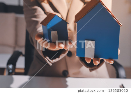 Female Real Estate Broker presenting and advised to model home and building project detail in the office, sign purchase sales contract, agreements concerned mortgage loan offer and insurance. 126585030