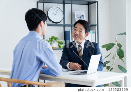 一位中年規劃師向一位年輕男子推銷 126585369