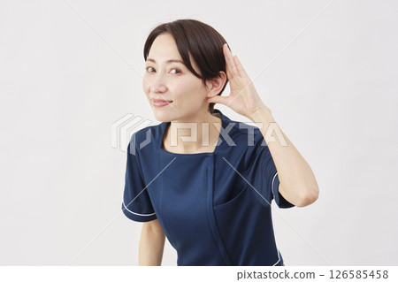 白色背景下，女美容護士用手摀住耳朵聆聽 126585458