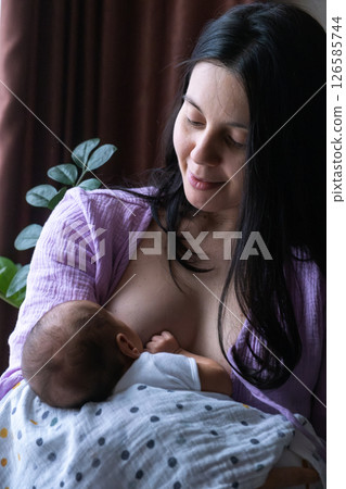 Mother Breastfeeding Baby by Window 126585744