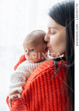 Tender Moment Between Mother and Baby by the Window 126585770