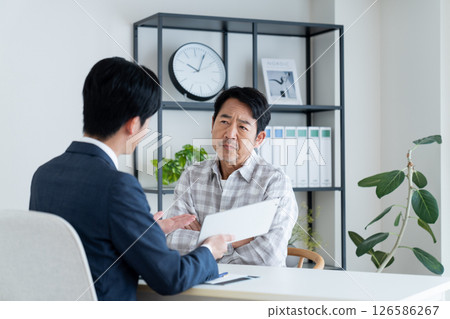 A middle-aged man consulting with a planner A middle-aged man consulting with a planner 126586267