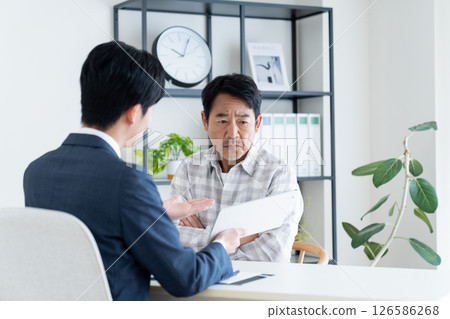 A middle-aged man consulting with a planner A middle-aged man consulting with a planner 126586268