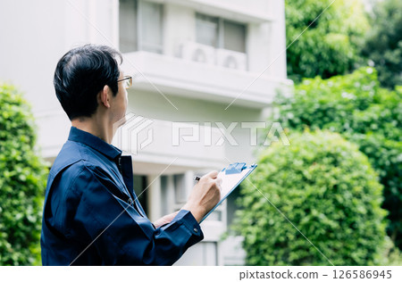 A middle-aged man inspecting equipment outdoors A middle-aged man inspecting equipment outdoors 126586945