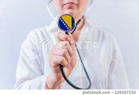 Female doctor holding stethoscope with Bosnia flag. National health system of Bosnia 126587150