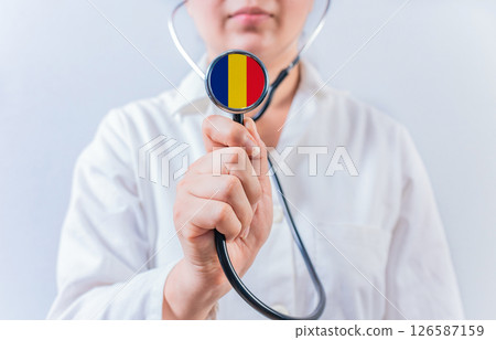 Female doctor holding stethoscope with Romanian flag. National health system of Romania Female doctor holding stethoscope with Romanian flag. National health system of Romania 126587159