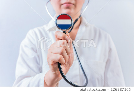 Female doctor holding stethoscope with Dutch flag. National health system of Netherlands 126587165
