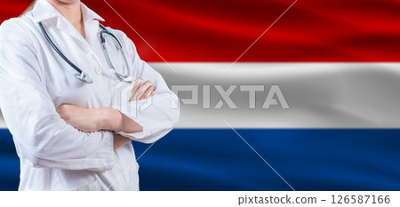 Doctor with crossed arms on Dutch flag. Netherlands health and care concept. Female doctor on Dutch flag 126587166