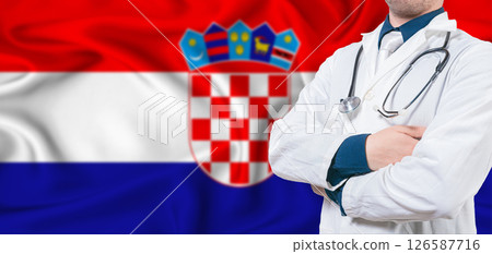 Croatia healthcare concept. Male doctor on Croatian flag. Doctor with crossed arms on Croatian flag 126587716