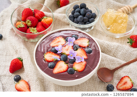 Acai bowl topped with strawberries and blueberries Acai bowl topped with strawberries and blueberries 126587894
