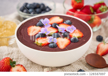 Acai bowl topped with strawberries and blueberries 126587897