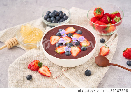 Acai bowl topped with strawberries and blueberries 126587898
