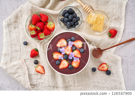 Acai bowl topped with strawberries and blueberries Acai bowl topped with strawberries and blueberries 126587900