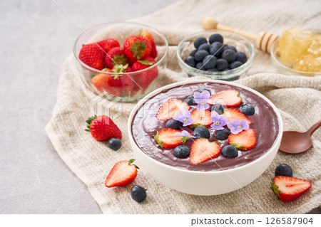 Acai bowl topped with strawberries and blueberries Acai bowl topped with strawberries and blueberries 126587904