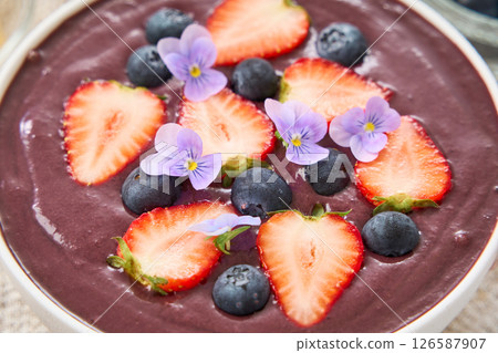 Acai bowl topped with strawberries and blueberries Acai bowl topped with strawberries and blueberries 126587907