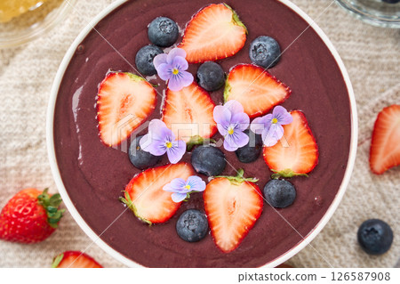 Acai bowl topped with strawberries and blueberries Acai bowl topped with strawberries and blueberries 126587908