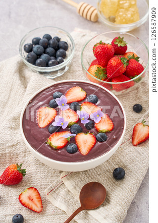 Acai bowl topped with strawberries and blueberries Acai bowl topped with strawberries and blueberries 126587909