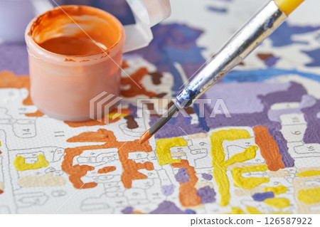 Close up of paint by numbers kit with brush and paint pots in vibrant colors Close up of paint by numbers kit with brush and paint pots in vibrant colors 126587922