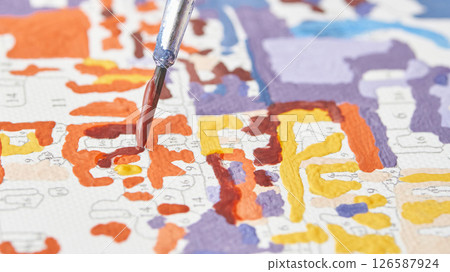 Close up of paintbrush on colorful paint by numbers canvas with vibrant colors Close up of paintbrush on colorful paint by numbers canvas with vibrant colors 126587924