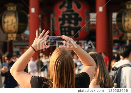 Foreign tourists taking photos of Sensoji Temple with their smartphones Foreign tourists taking photos of Sensoji Temple with their smartphones 126588436