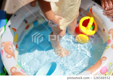 A toddler having fun playing in water on the balcony A toddler having fun playing in water on the balcony 126588552